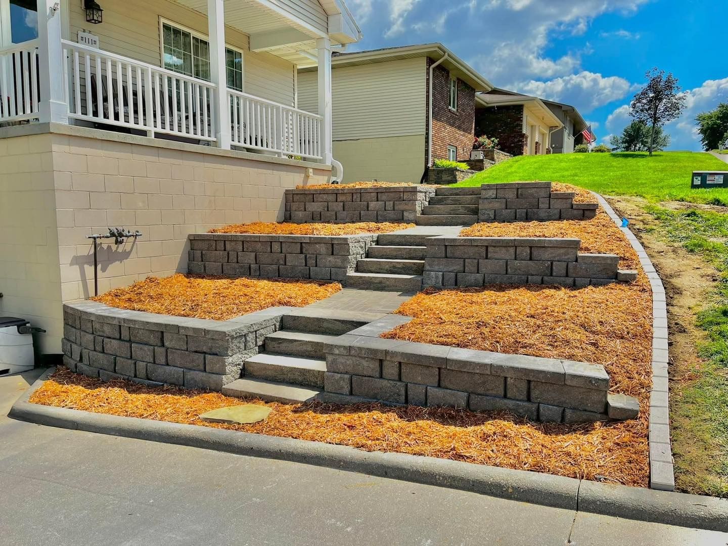 A yard with steps and landscaping in the middle of it.